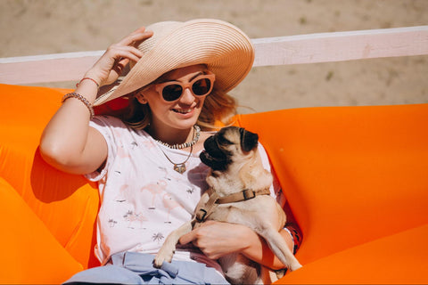 lady in hat holding a dog