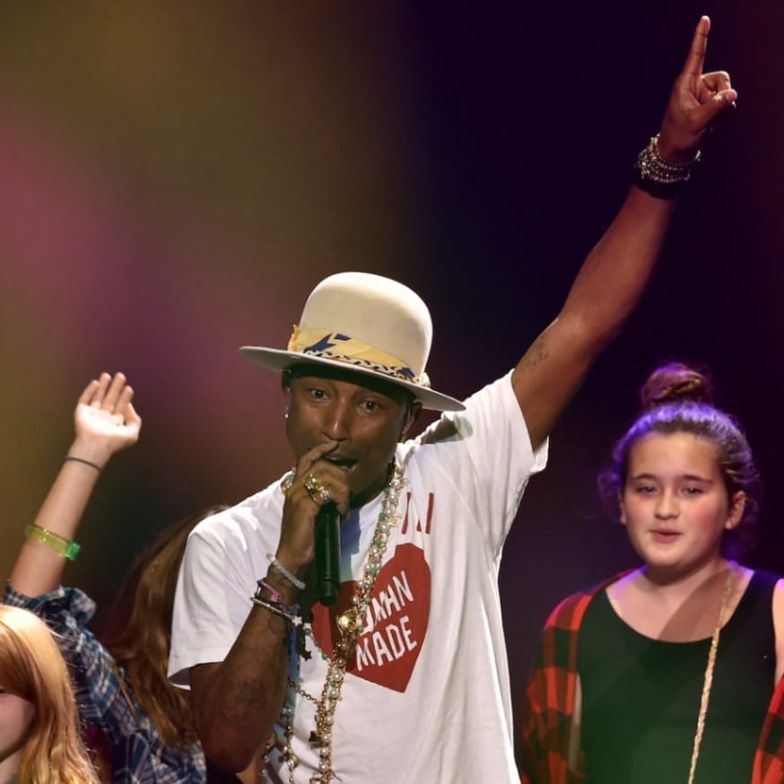 Pharrell Williams wears an open-crown Mountie-style hat at the Jingle Ball