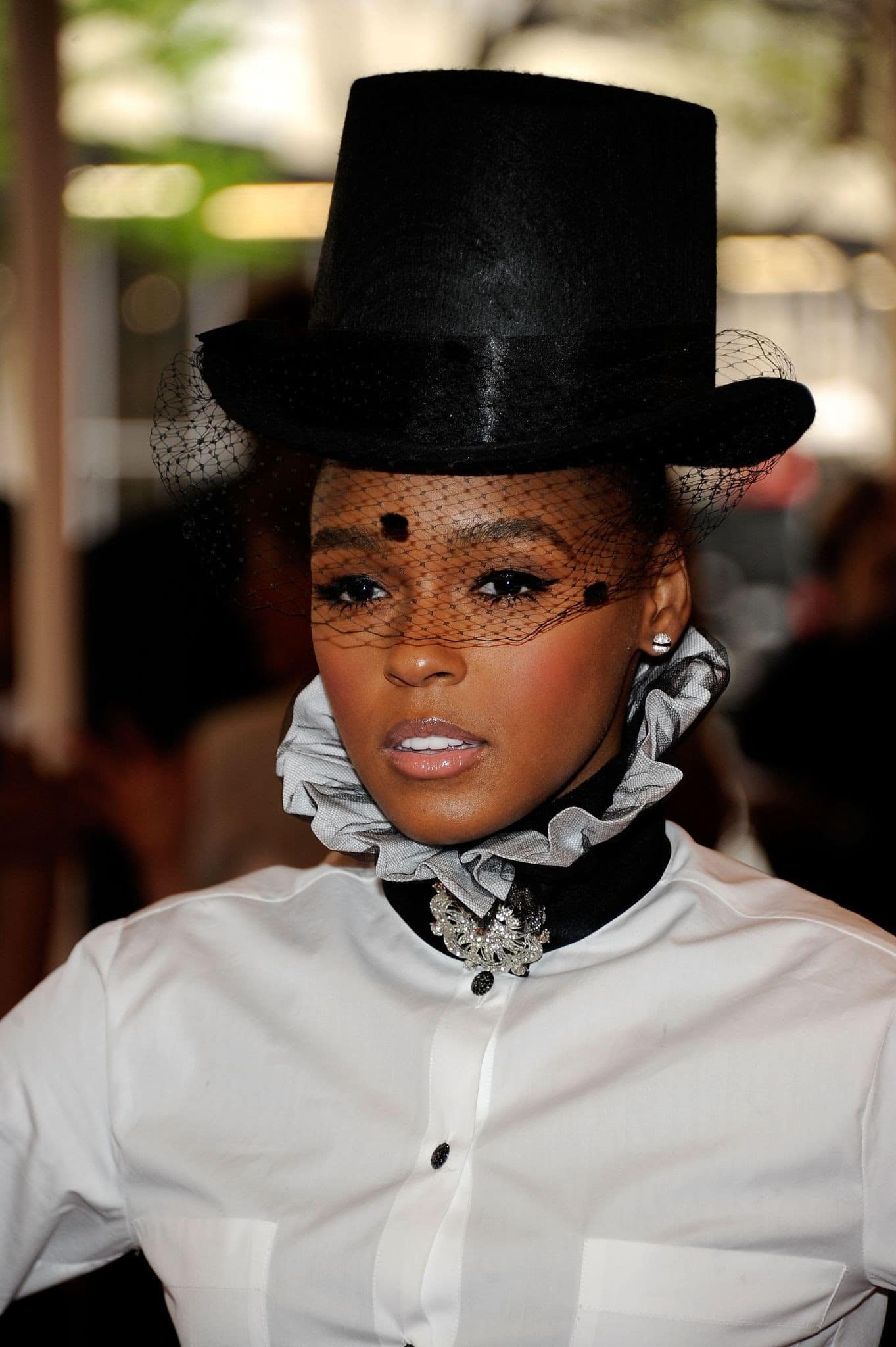 Janelle Monae wears a black top hat with a mesh veil at the \”Alexander McQueen: Savage Beauty\” Costume Institute Gala
