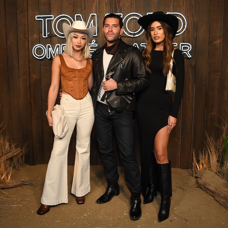 Gregory Dava (C) flanked by Tom Ford cowboy hat wearing guests at the Ombré Leather Parfum launch event in West Hollywood, California.