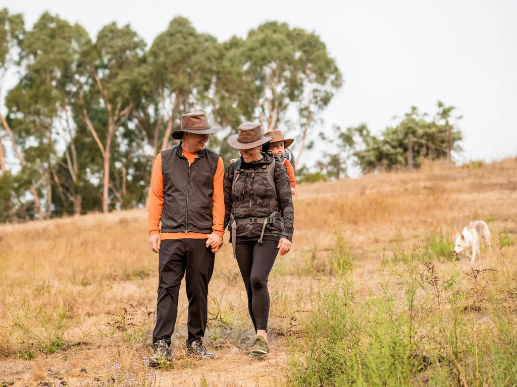 Image of a Husband walking with his wife (she's carrying their baby in a pack on her back) all wearing the Crusher | Leather Outback Crushable Hat by American Hat Makers