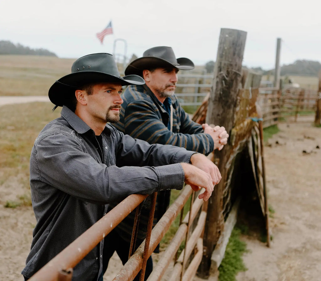 image of two men leaning on a fence wearing the Hollywood Leather Cowboy Hat by American Hat Makers