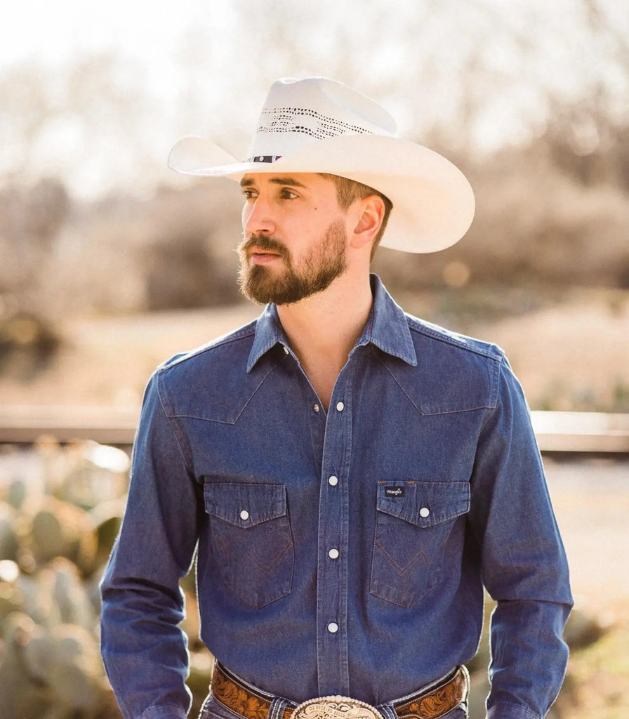 image of guy dressed in a long sleeve blue button up, blue jeans, a big belt buckle and the Billings Straw Cowboy Hat by American Hat Makers