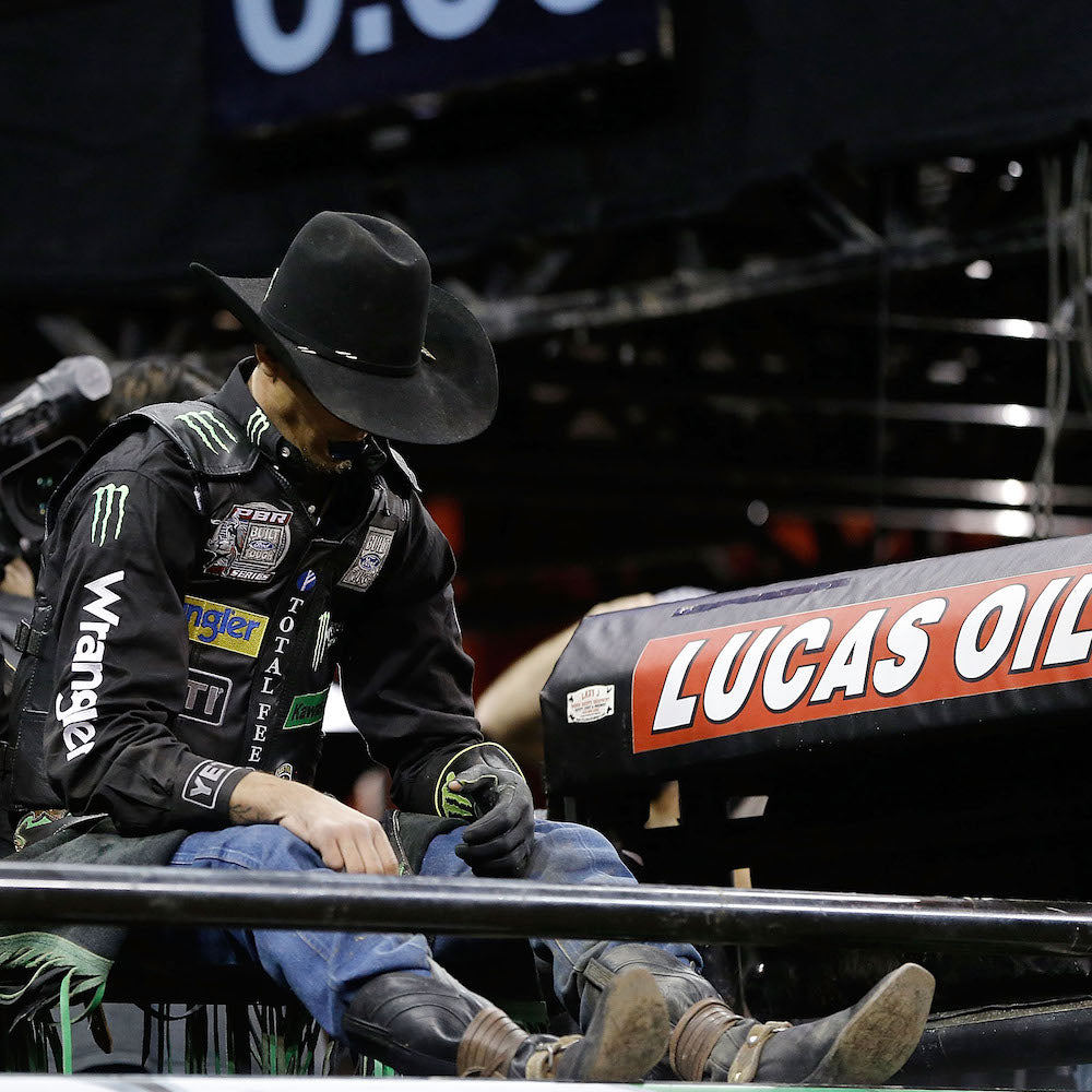J.B. Mauney wears a traditional black felt cowboy hat with a Cattleman crease while resting on the chutes in Madison Square Garden. His sponsorship patch is located on the back.