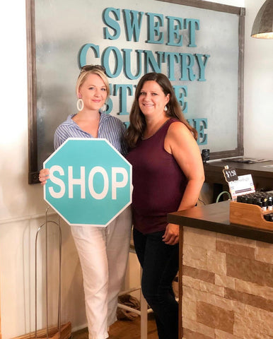 Women business owner with shop sign in boutique