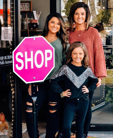 women and girl with boutique sign