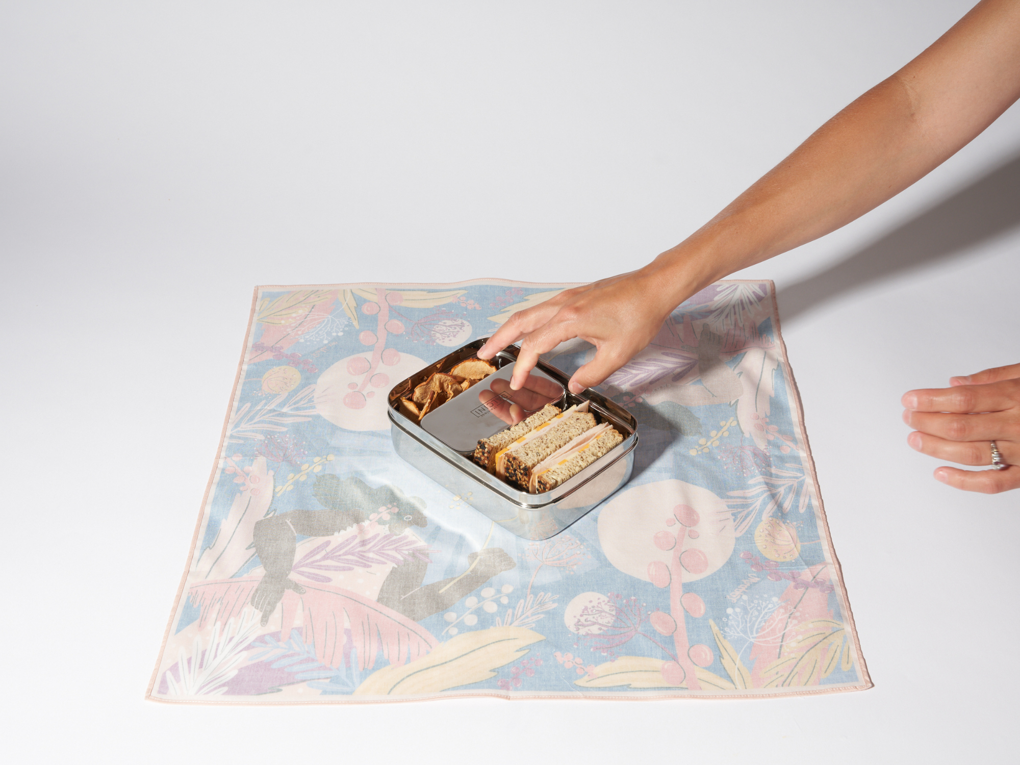 caja bento colocada en medio de un furoshiki con las esquinas paralelas a los lados de la caja bento