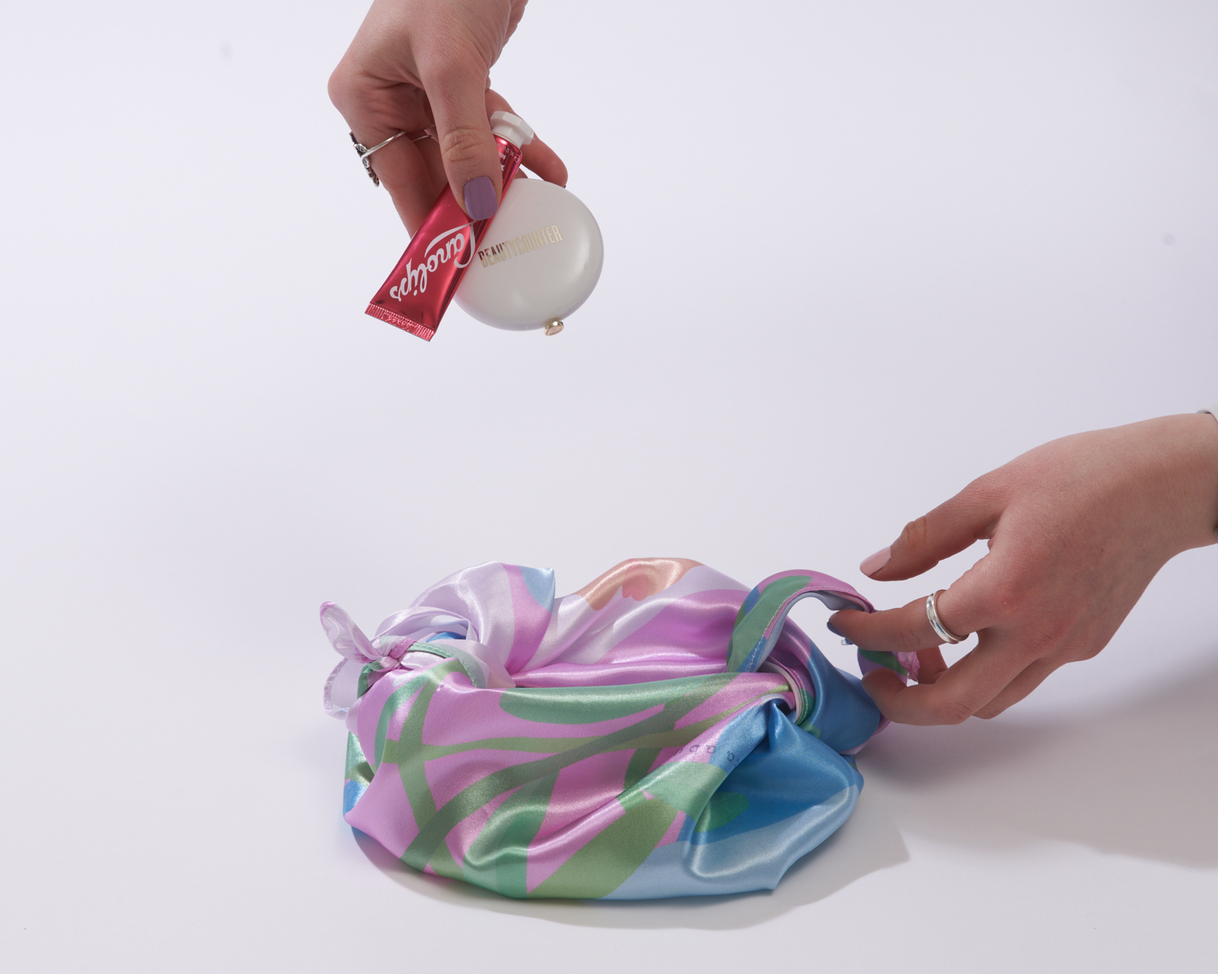 Imagen de alguien poniendo maquillaje/cuidado de la piel en su bolso furoshiki.