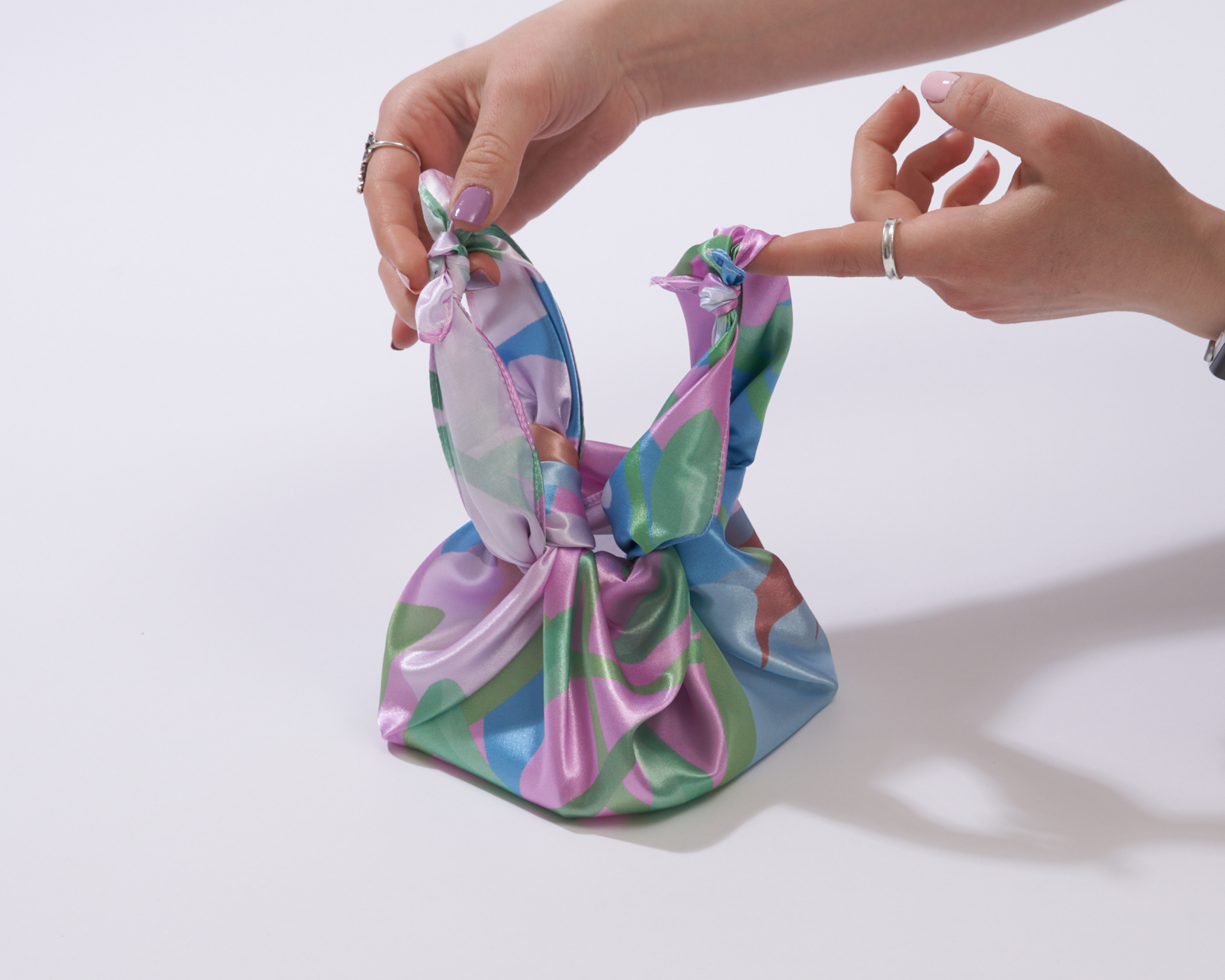 image of someone holding the two handles of a furoshiki 