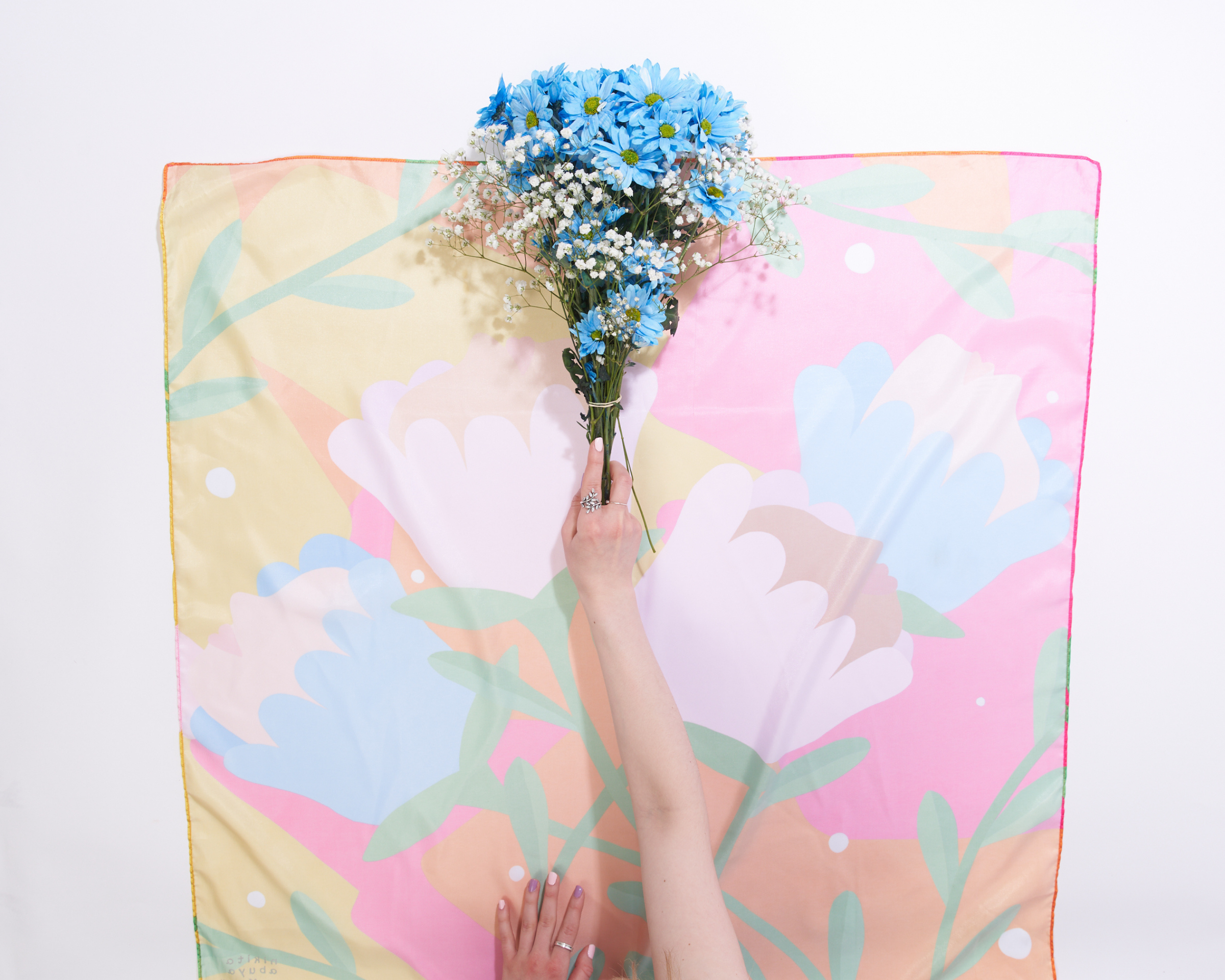 image of someone placing a bouquet of flowers at the center of their furoshiki 