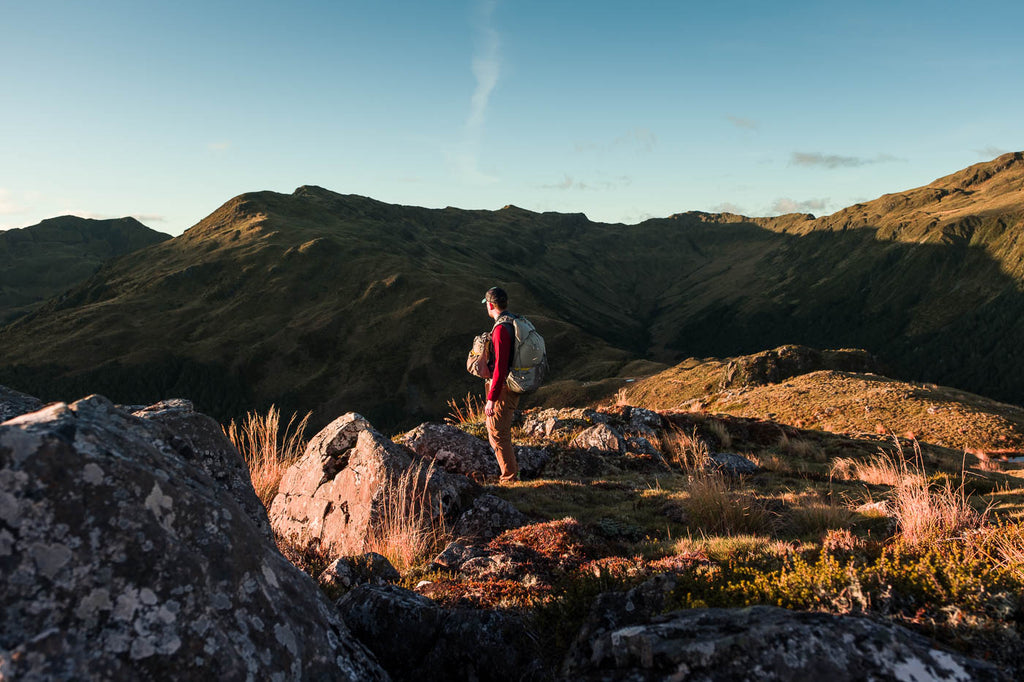 man standing in sunset on a mountain