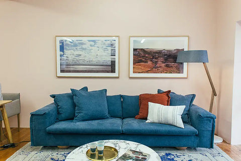 Two pictures above a blue couch