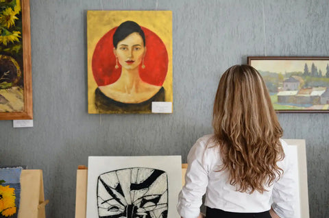 A woman looking at the painting and thinking about using art as conversation starters.