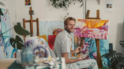 A smiling man painting at his home