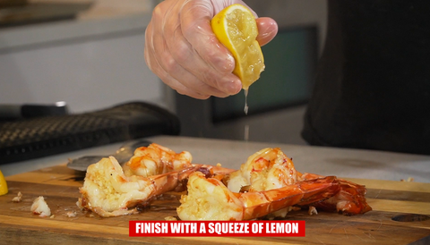 squeezing lemon on tiger prawns