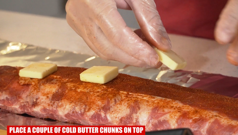 placing butter on baby back ribs