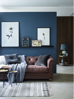 Blue accent wall with brown furniture