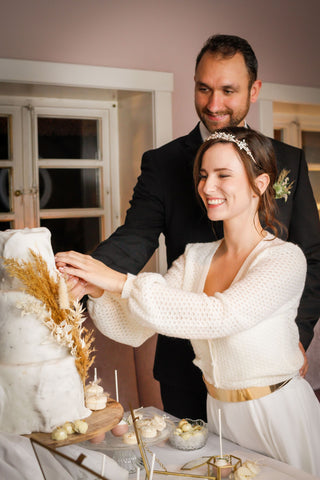 Braut und Bräutigam schneiden die Hochzeitstorte an