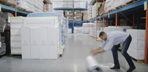 Man rolling out his mattress wrapped in plastic