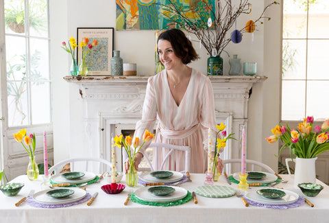 A table laid with plates, dinner candles and flowers