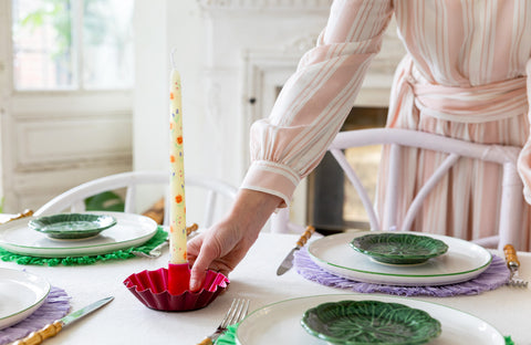 A dinner candle being placed on a table