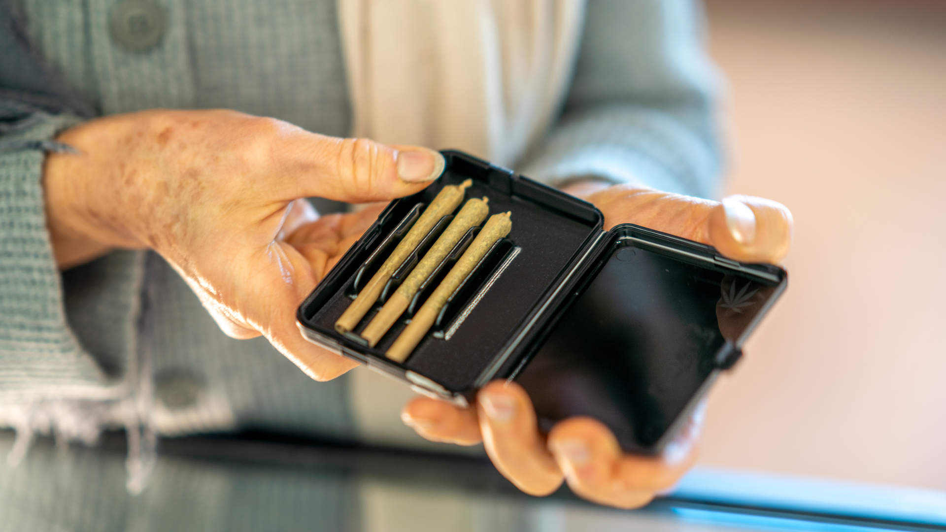 senior holding pack of cannabis pre-rolls