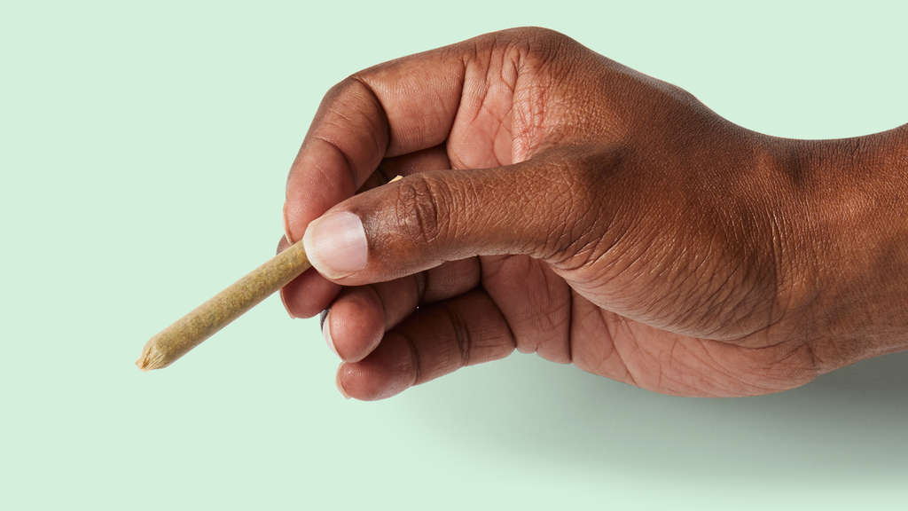 man's hand holding cannabis joint