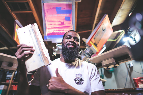 A man smiles and holds up a squeegee