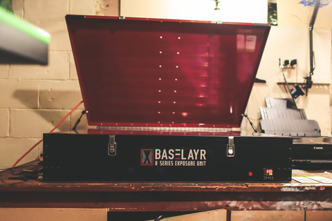 A baselayr exposure unit sits open on a table