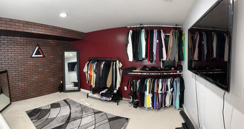 A rack of shirts stands in the corner of a room