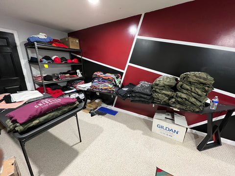 Camo shirts sit on a table in a corner of a shop