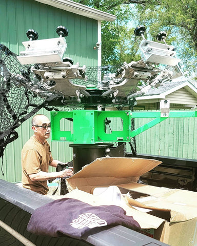 A man helps to load a Riley 6X4 press onto a trailer