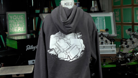 A grey hoodie with a back placement in white ink