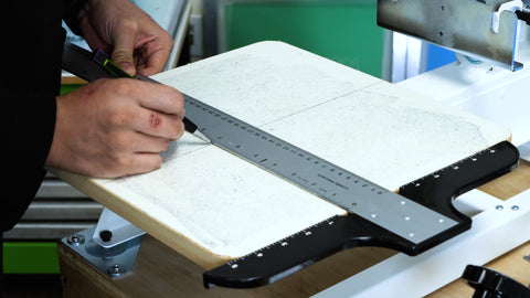 A person marking the center line on the Screen Printer Starter Press platen