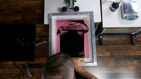 A printer pulling black ink on a screen