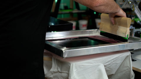 A man in a black shirt prints black in across a screen