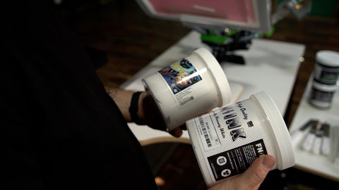 a person holds two kinds of ink: water based white and plastisol ink white