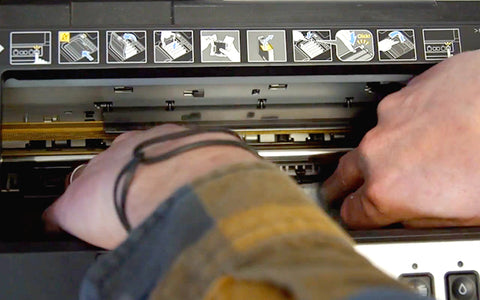 hands adjusting the print head in an Epson printer