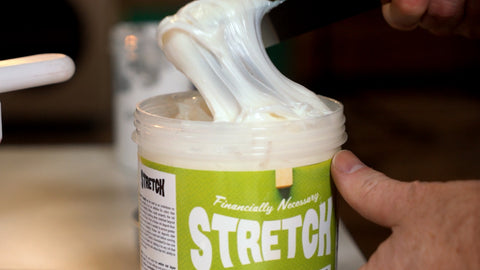 a bucket of stretch ink with the ink stretching out via spatula