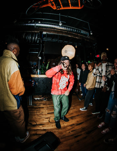 A man raps into a microphone at a concert