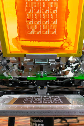 A vacuum platen holds a black paper with business cards printed on it