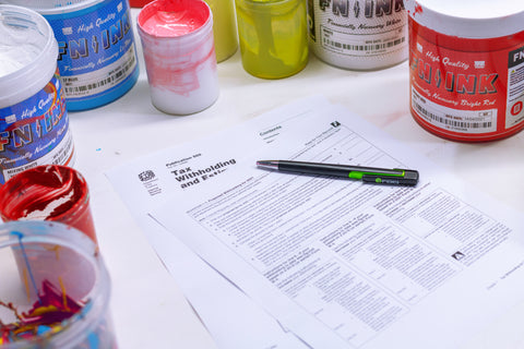 a piece of tax documentation with a pen on it and ink surrounding it