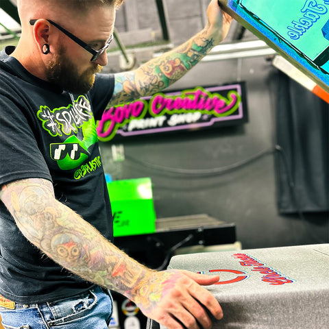 A man inspects a print on a manual press