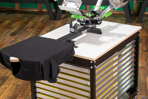 A riley hopkins 150 press sits on a press cart with a loaded black shirt on the platen