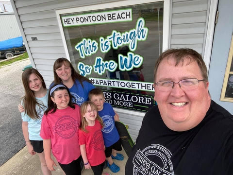 family posing for a selfie in front of their print shop