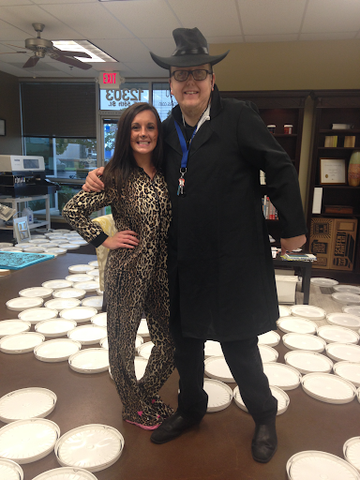 A man and a woman dressed up for halloween among ink lids