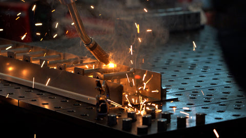 A welder welds a piece of metal together