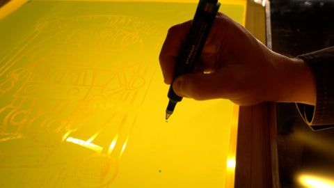 Una mano sostiene un bolígrafo bloqueado y dibuja sobre agujeros en una pantalla