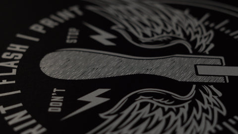 a close up of a white plastisol ink print on a black shirt