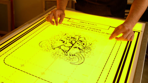 A person aligning film using a pre-registration template on a light table